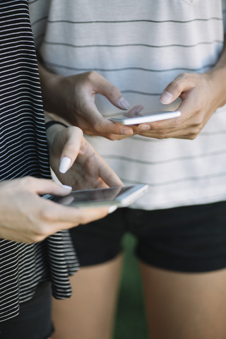 Hands of young women holding smartphones stock photo