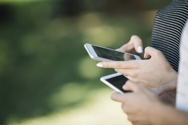 Hands of young women holding smartphones - ALBF00101