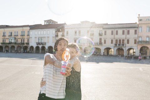 Italy, Padua, two young women with soap bubble machine stock photo