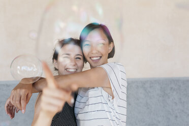 Zwei junge Frauen spielen mit Seifenblasen - ALBF00121