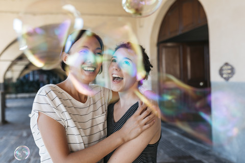 Two young women playing with soap bubbles stock photo