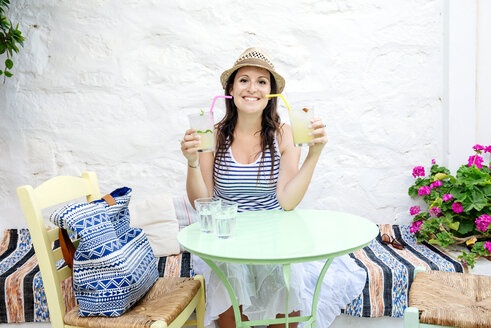 Woman drinking two mojitos sitting in a bar outdoors - GEMF01466