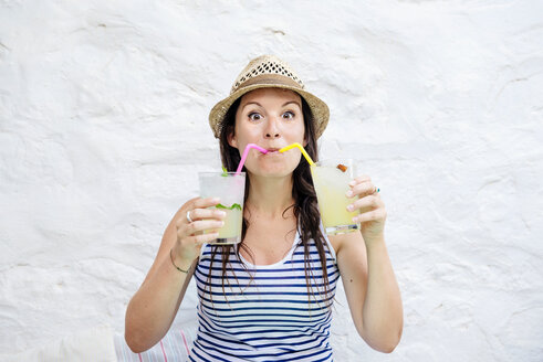 Portrait of woman drinking two mojitos - GEMF01467