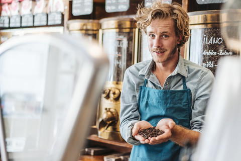 Porträt eines Kaffeerösters in seinem Geschäft mit Kaffeebohnen, lizenzfreies Stockfoto