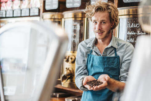 Porträt eines Kaffeerösters in seinem Geschäft mit Kaffeebohnen - KNSF00879