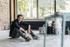 Man sitting on floor in unfinished room - KNSF00884