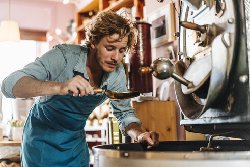 Kaffeeröster in seinem Geschäft bei der Prüfung von Kaffeebohnen - KNSF00893