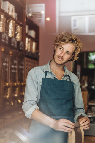 Coffee roaster in his shop packing bag of coffee stock photo