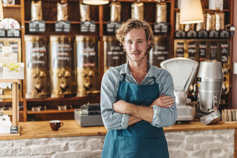 Porträt eines selbstbewussten Kaffeerösters in seinem Geschäft, lizenzfreies Stockfoto