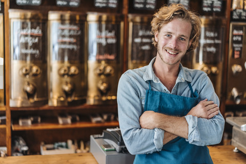 Porträt eines lächelnden Kaffeerösters in seinem Geschäft, lizenzfreies Stockfoto