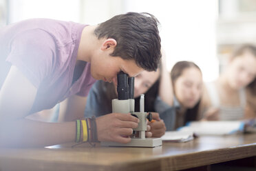 Naturwissenschaftsstudent im Unterricht beim Blick durch das Mikroskop - ZEF12645