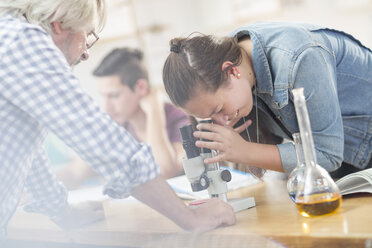 Student der Naturwissenschaften mit Lehrer im Unterricht, der durch ein Mikroskop schaut - ZEF12648