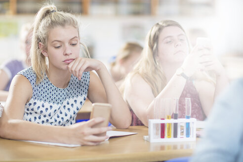Bored teenage girl in high school chemistry class using cell phone - ZEF12649