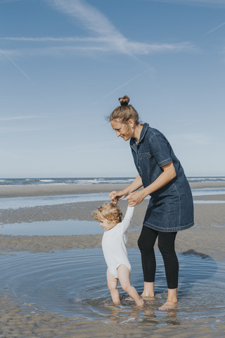 Niederlande, Schiermonnikoog, Mutter mit kleiner Tochter am Strand, lizenzfreies Stockfoto