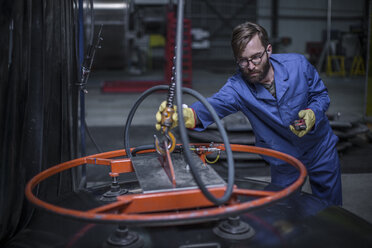 Fabrikarbeiter beim Anbringen eines industriellen Stahlhakens - ZEF12691