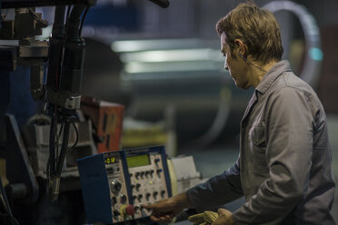 Arbeiter bei der Bedienung von Maschinen am Schaltpult in einer Fabrik - ZEF12697