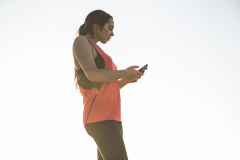 Eine Sportlerin benutzt ihr Telefon, lizenzfreies Stockfoto