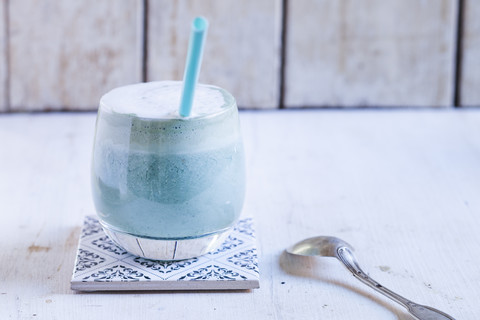 Ein Glas blau gefärbter Milchkaffee mit Spirulina-Algen, veganer Pflanzenmilch, Ingwer und Reissirup, lizenzfreies Stockfoto