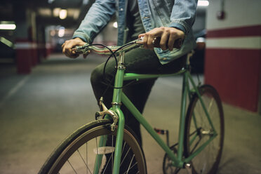 Mann mit seinem Fixie-Fahrrad in einer Garage - RAEF01717