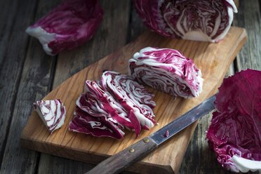 In Scheiben geschnittener Radicchio und Küchenmesser auf Holzbrett - YFF00632