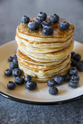 Dish with pile of pancakes and blueberries with maple sirup - SARF03168