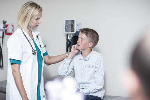 Eine Kinderärztin untersucht einen Jungen mit einem Otoskop - ZEF12711