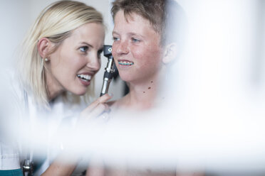 Female pedeatrician examining boy with an otoscope - ZEF12718