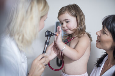 Little girl at the pedeatrician playing with otoscope - ZEF12727