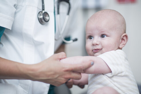 Female pedeatrician holding baby at examination - ZEF12739