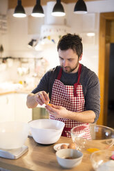 Mann steht in der Küche und bereitet Kuchenteig vor - HAPF01328