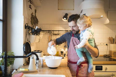 Vater und kleiner Junge in der Küche beim Backen eines Kuchens, lizenzfreies Stockfoto