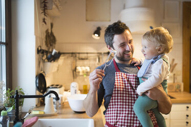 Father and baby boy in kitchen baking a cake - HAPF01336