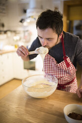 Man standing in kitchen, preparing cake dough - HAPF01340