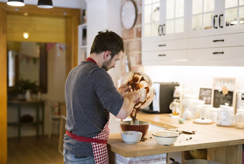 Mann steht in der Küche und backt Ringkuchen, lizenzfreies Stockfoto