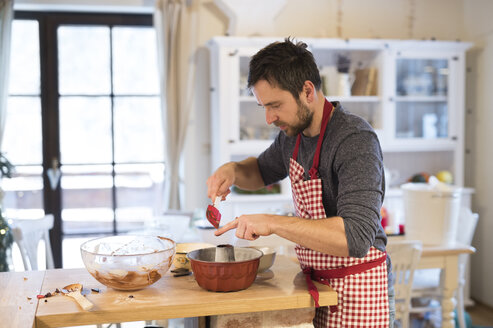 Mann steht in der Küche und backt Ringkuchen - HAPF01351