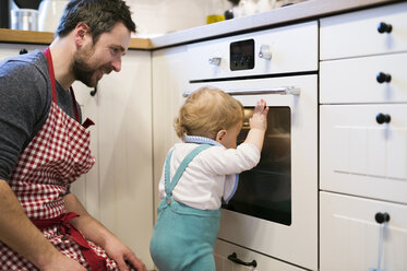 Father and baby boy in kitchen baking a cake - HAPF01354