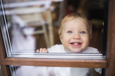 Laughing baby boy looking out of window - HAPF01359