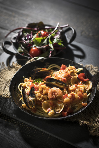 Spaghetti Frutti di Mare mit Blattspinat und Salatplatte, lizenzfreies Stockfoto