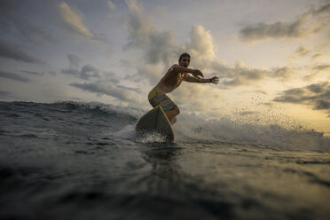 Indonesia, Bali, surfer at sunset - KNTF00629