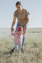 Niederlande, Schiermonnikoog, Mutter geht mit kleiner Tochter auf einer Wiese spazieren - DWF00270
