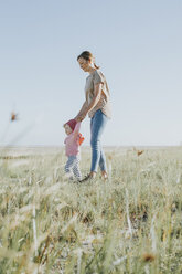 Niederlande, Schiermonnikoog, Mutter geht mit kleiner Tochter auf einer Wiese spazieren - DWF00274