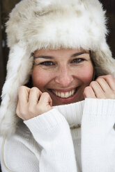 Portrait of smiling woman wearing fur cap and turtleneck pullover in winter - FSF00732