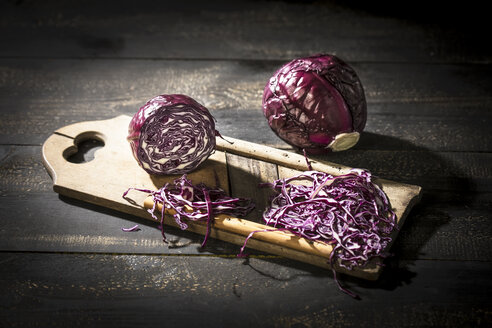 Ganzer und geriebener Rotkohl mit Reibe auf dunklem Holz - MAEF12115