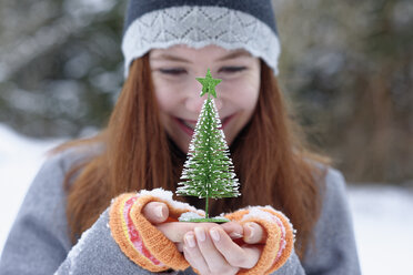 Teenager-Mädchen hält kleinen Weihnachtsbaum - LBF01552