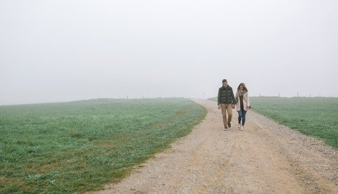 Paar auf einem Weg an einem nebligen Wintertag, lizenzfreies Stockfoto