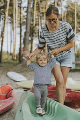 Netherlands, Schiermonnikoog, mother walking with little daughter on a boat - DWF00285