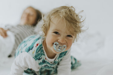 Porträt eines glücklichen kleinen Mädchens mit Mutter im Bett - DWF00291