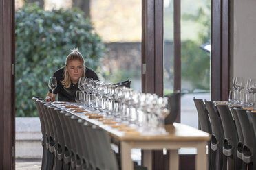 Kellnerin stellt eine Reihe von Weingläsern im Restaurant auf - ZEF12748