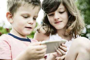 Bruder und Schwester benutzen ein Smartphone - JATF00959