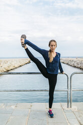 Junge Frau macht Yoga-Posen am Strand - GIOF01753